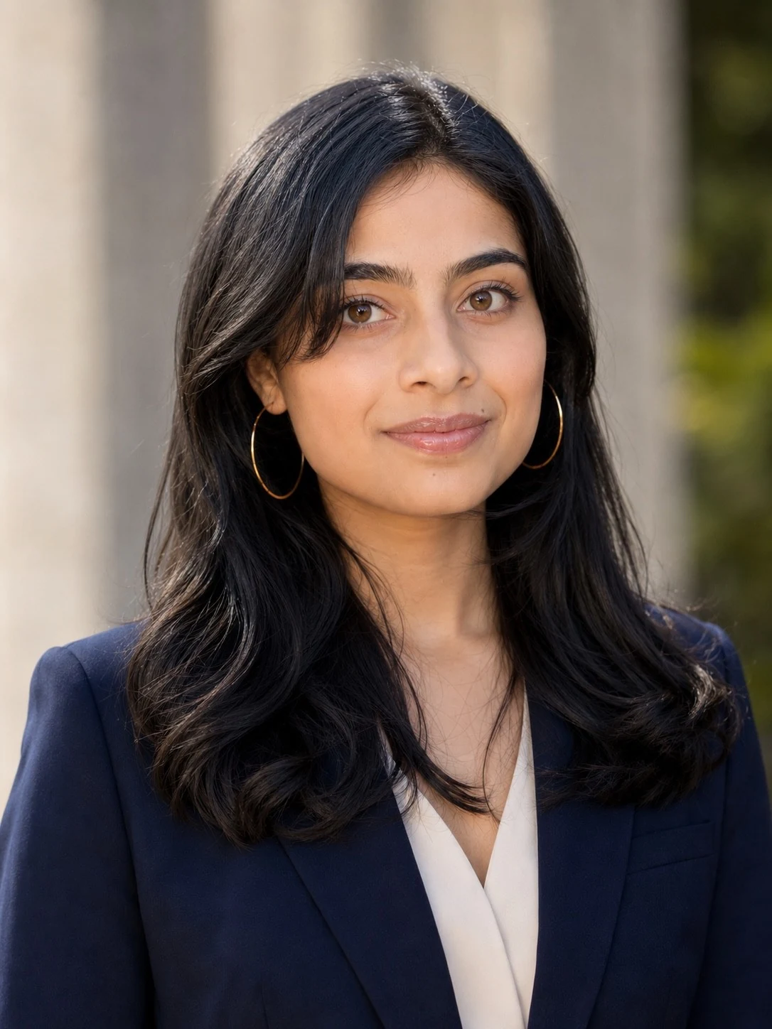 Professional portrait of Ria Bahadur in a navy blazer